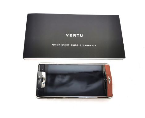 A boxed Vertu Signature touch Bentley mobile phone. The Vertu for Bentley is made from lightweight but durable grade-5 titani
