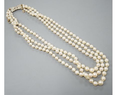 A modern triple strand graduated cultured pearl choker necklace, with diamond chip set white metal clasp, 38cm.