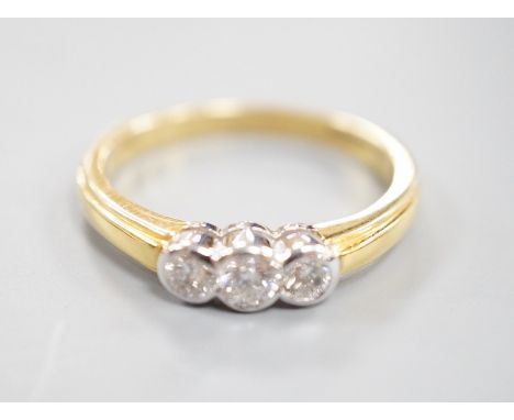 A modern 18ct gold and collet set three stone diamond ring, size P, gross weight 3.6 grams, total diamond weight approx. 0.42