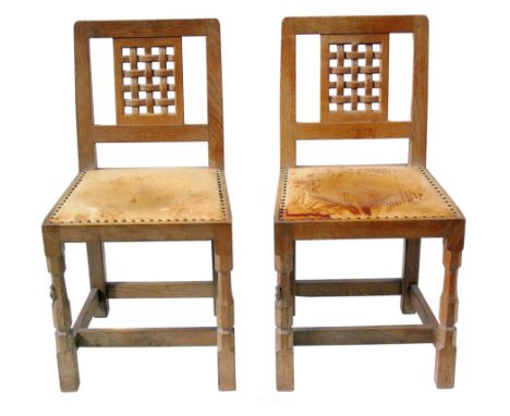 A pair of Robert "Mouseman" Thompson single dining chairs, each with low-back pierced lattice work carved splat, close nailed