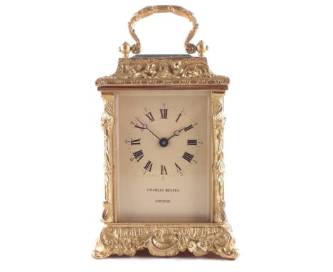 20th century carriage clock, cast brass frame, gilded of rococo design, bevelled glass panels covering champagne tinted dial 