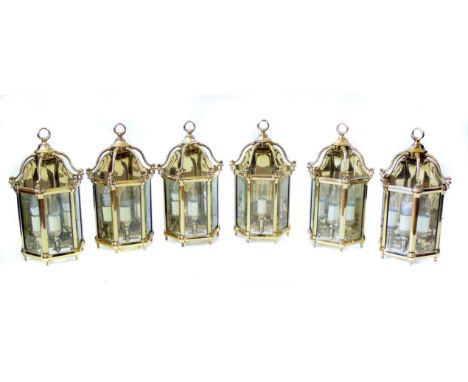 Six 20th century heavy gauge brass wall lamps, each with three bevelled glassed panels covering three electric light sockets,