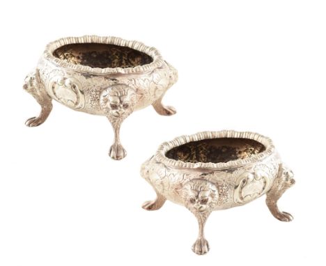 Pair of white metal salts , cauldron shaped bodies with embossed floral decoration, four lion mask and paw feet, stamped to b