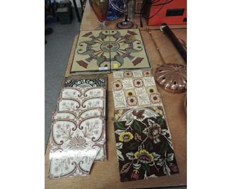 A selection of antique tiles including encaustic set, enamel and floral prints 
