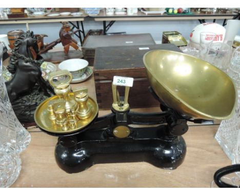A vintage cast scale set by Boots Chemist with black enamel, brass fitments and solid cast weight set