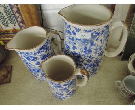 A selection of vintage ceramic graduated jugs in delft ware chintz style with lustre edge work