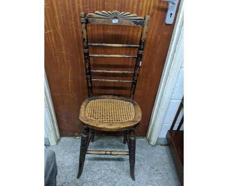 A Victorian ebonized correction chair, fan shaped crest rail above four horizontal spindles, cane seat on compressed bobbin f
