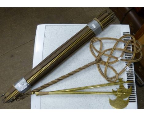 A bundle of brass stair rods, a cane carpet beater and a pair of brass ornamental axes