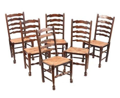 SET OF SIX OAK LADDER BACK DINING CHAIRS WITH RUSH SEATS.RAISED ON TURNED LEGS.HEIGHT: 39 INCHES.WIDTH: 20 INCHES.DEPTH: 16 I
