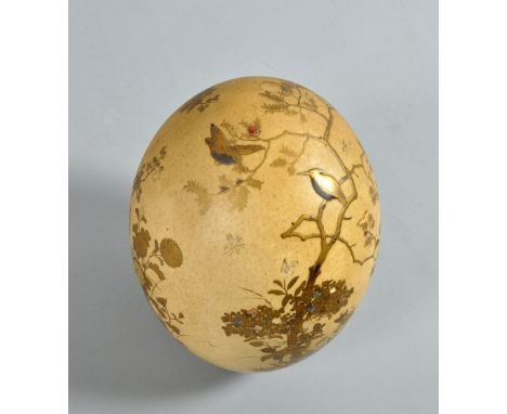 A Meiji period ostrich egg decorated in gilt low relief and mother of pearl and coloured stone depicting birds, insects and f