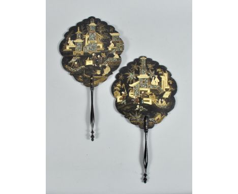 A pair of 19c Oriental black lacquered hand fans , gilt decorated leaves with mother of pearl highlights depicting figures bo