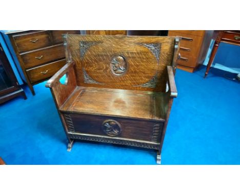 A carved oak monks bench with rising seat