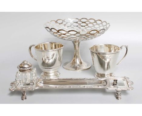 A Collection of Four Items, comprising two differing christening-mug; an instand with Celtic scroll cast border, one bottle l