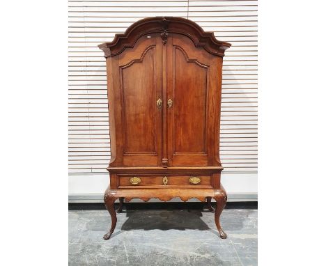 19th century continental armoire on stand, having broken-arch and cavetto cornice, shelves enclosed by pair framed panelled d