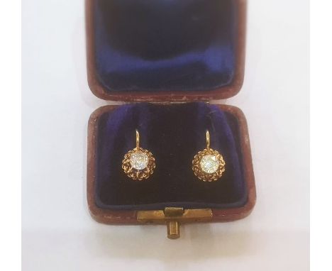 Continental gold-coloured metal and diamond earrings, the circular old cut stone in ornate pierced fleur-de-lys border, 0.55c