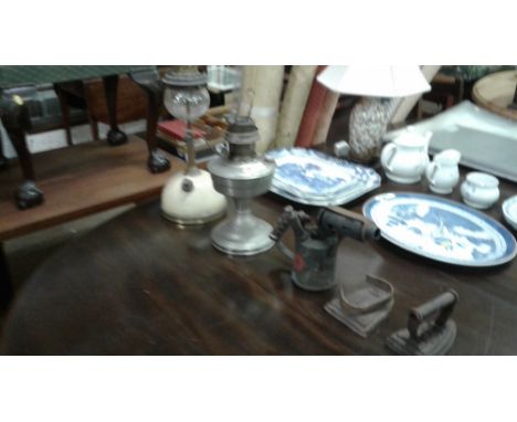 A blow lamp; two flat irons and two oil lamps