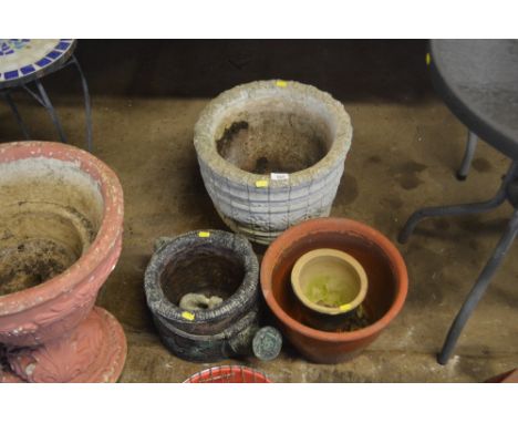 A concrete planter; a planter in the form of a watering can and a terracotta planter etc