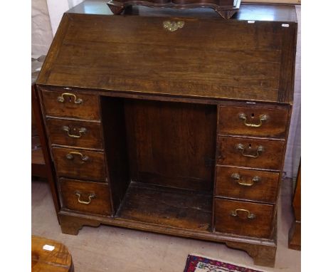 A Georgian oak bureau, with fall-front, recessed cupboard flanked by 4 short drawers, bracket feet, W96cm 