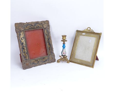 A 19th century hand painted porcelain and brass candlestick, a brass-framed photo frame, and a painted composite photo frame,