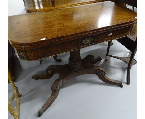 A Regency mahogany fold over card table, on a spiral and carved turned centre column, sabre leg platform base with ormolu mou