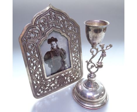 An Islamic design silver photo frame, with scrolled and pierced decoration, and a stylised silver candlestick 