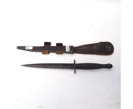 A Fairbairn Sykes style commando fighting knife, ribbed grip with leather scabbard, unmarked, blade length 17.5cm 