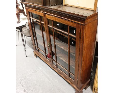 An Edwardian mahogany bookcase with 2 lattice-glazed doors, on shaped bracket feet, W135cm, H119cm 