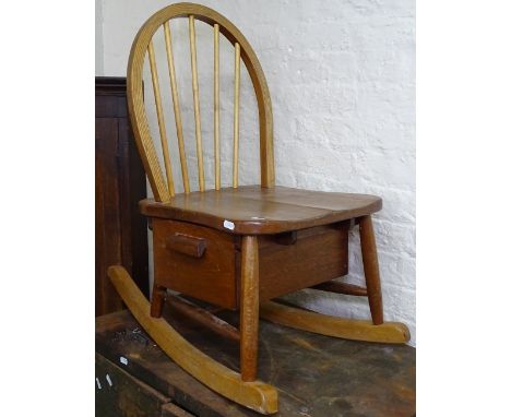 A mid-century child's Ercol stick-back rocking chair, with drawer to the underside of the seat 