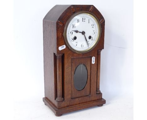 An Art Nouveau oak-cased 8-day mantel clock, column supports with glass pendulum viewing aperture, case height 37cm 