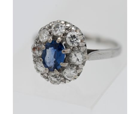 An 18ct sapphire and diamond cluster ring, the cornflower sapphire approx. 0.68ct set in white gold, size L, with detailed in
