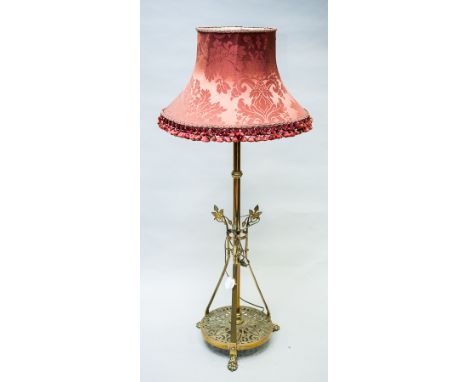 VICTORIAN BRASS TELESCOPIC FLOOR LAMP 
on a pierced circular base with three upright supports, on cast paw feet, 105 cm high 