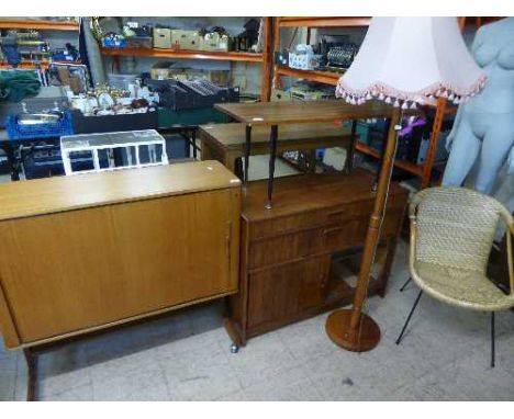 A teak television cabinet together with a teak radiogram cabinet, coffee table, standard lamp with shade and wicker armchair 