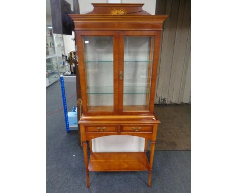 A Bradley yew wood double door display cabinet on stand, fitted two drawers and a shelf
