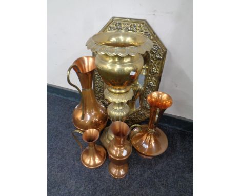 An octagonal brass framed embossed mirror together with a brass planter and four copper and brass jugs 