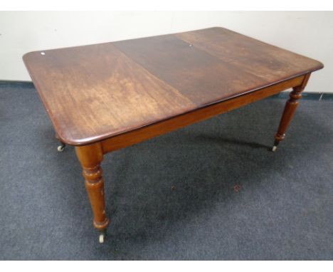 A Victorian mahogany rectangular dining table on ceramic casters together with a set of four chairs