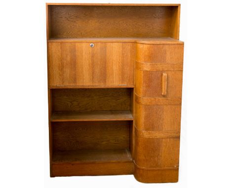 An Art Deco oak bureau, the curved cupboard door with raised horizontal banding fitted with pigeon holes, beside a fall front