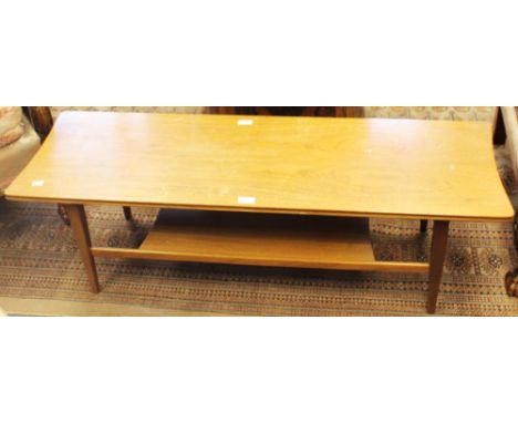 A mid 20th century teak coffee table, the rectangular top with shaped ends, on four tapered square section legs united by a l