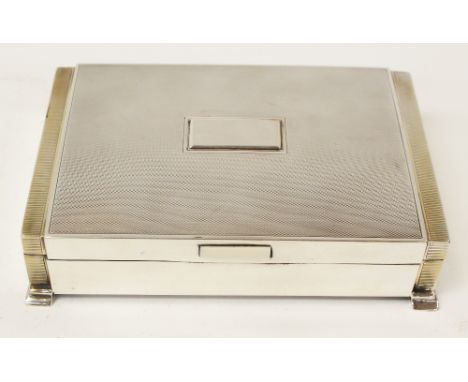 An Art Deco style silver cigar box, engine turned, rectangular section, stepped form with gilded banding and ivorine thumb pi