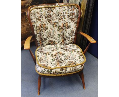 An Ercol Windsor high back armchair, designed circa 1955, stained wood with spindle back and cushions, original label