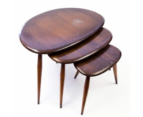 A nest of Ercol Windsor pebble tables, designed circa 1955, stained elm and beech, original sticker labels (3)