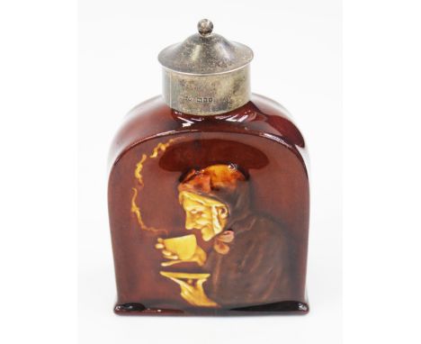 A Royal Doulton Kingsware tea caddy, treacle glazed and moulded with an old woman drinking tea, the silver lid of plain cylin