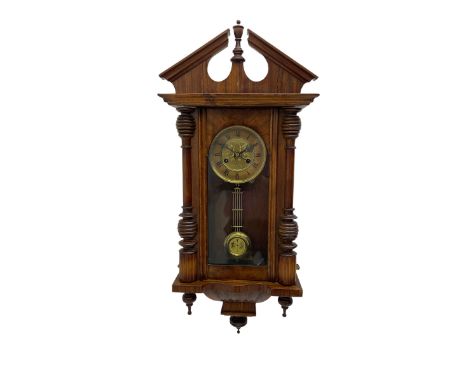 German early 20th century wall clock in a mahogany case with an architectural pediment and turned finial, with applied carvin