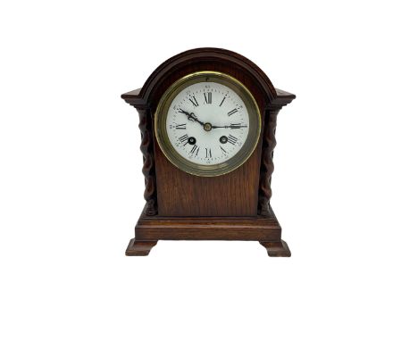 Early 20th century oak cased mantle clock, with a break arch top and barley twist columns,  low plinth raised on oak bracket 