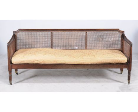 A mahogany sofa, 19th century, with ratan back and sides and removable seat cushion 194cm long 