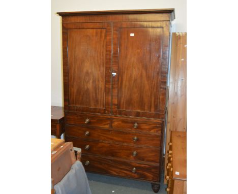 A Regency mahogany linen press, circa 1820 and adapted to a hanging wardrobe, the base with two short and three long graduate