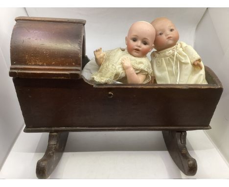 Antique wooden dolls early cradle with shaped canopy and rocking mechanism to include a 12’ JDK plaster mold dome baby charac