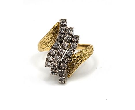 A yellow metal and diamond crossover ring, the textured shoulders set with three rows of round brilliant-cut diamonds, ring h