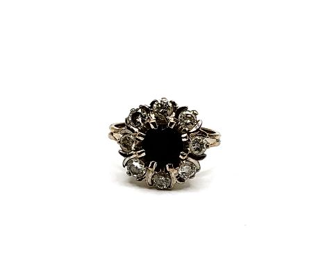 An 18ct white gold, diamond, and sapphire ring, set with a round-cut sapphire of approximately 67 mm diameter, within a borde