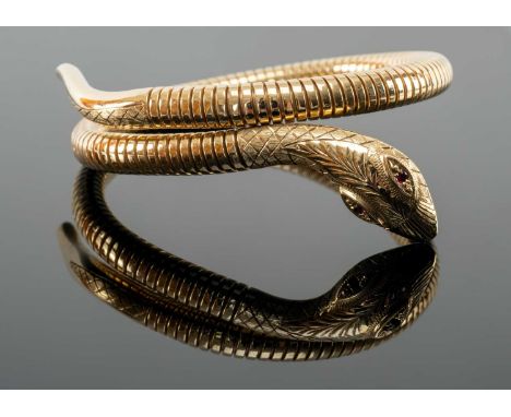 9CT GOLD COILED SNAKE BANGLE, the snake head terminal set with two ruby eyes, 26.3gmsProvenance: private collection Pembrokes