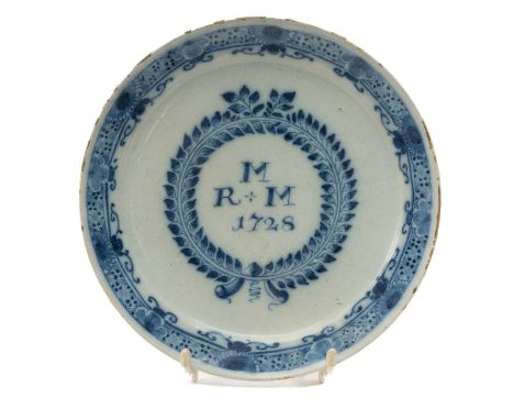 GEORGE II ENGLISH DELFT MARRIAGE PLATE, dated 1728, centre painted with initials 'R+M M' within laurel wreath, the border wit